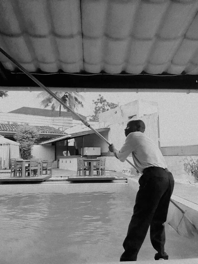 Pool technician cleaning a pool with a telescoping pole